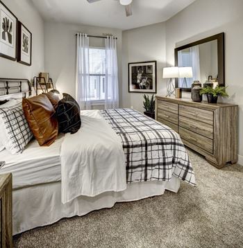 A bedroom with a bed, dresser, and mirror.